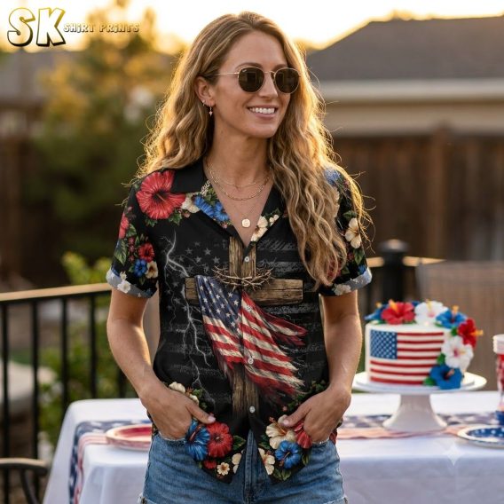 Woman wearing america 250 Hawaiian shirt, black with wooden cross wrapped in American flag, red white and blue hibiscus flowers and lightning bolt pattern