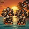 Black Hawaiian shirt with skull and orange floral print, displayed on ghost mannequin at sunset beach setting