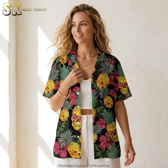 Female lifestyle closeup of a black Hawaiian shirt with yellow skull pineapples, sunglasses detail, pink flowers, and green tropical leaves as a Halloween costume