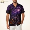 Men's Halloween Hawaiian shirt shown on male model in studio, printed with a spooky castle, full moon, glowing jack-o'-lanterns, bats, and barren trees in purple and orange tones