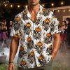 Male model wearing a men's Halloween Hawaiian shirt with skeleton jack-o'-lantern head figures, black crows, and autumn leaves on the pattern