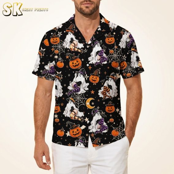 Male model wearing a mens Halloween Hawaiian shirt printed with ghosts in witch hats, jack-o-lanterns, bats, and candy corn on a black background