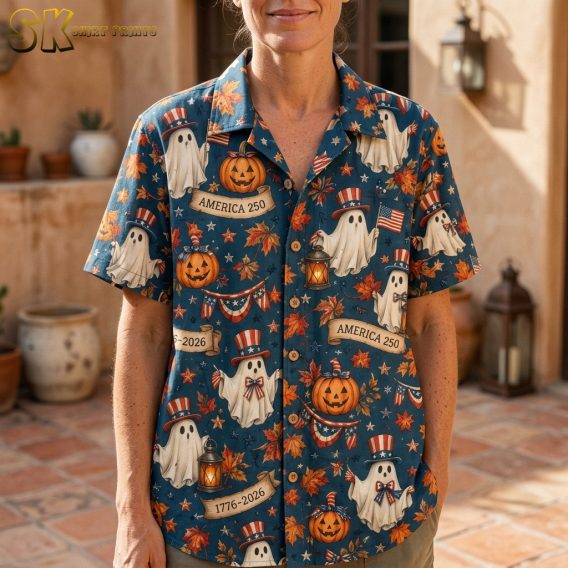 Close-up of a woman wearing a dark blue pumpkin hawaiian shirt, showing detailed cartoon ghosts in Uncle Sam hats, carved jack-o'-lanterns, autumn leaves, and patriotic bunting.