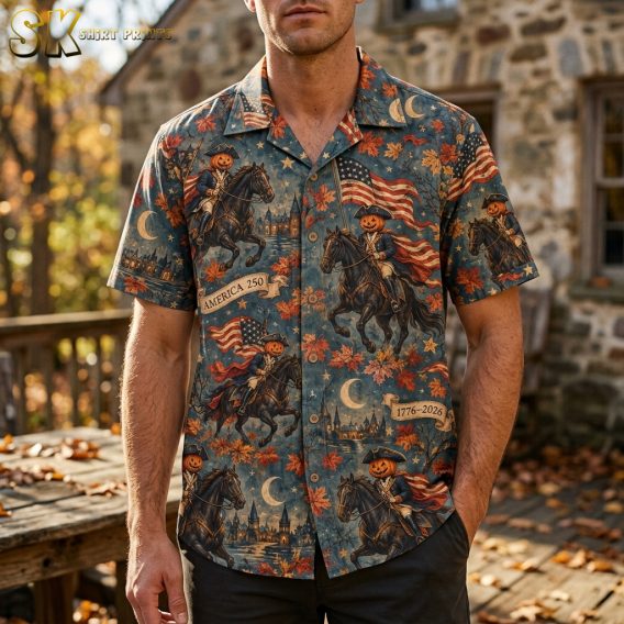 Man wearing a mens halloween hawaiian shirt printed with pumpkin-headed colonial horse riders, American flags, and autumn leaves on a muted blue background.