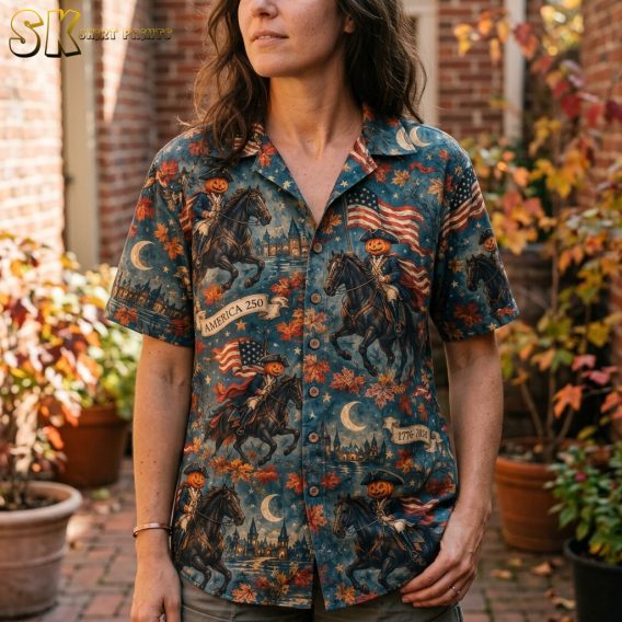 Close-up of a spooky hawaiian shirt worn by a woman, showing detailed pumpkin-headed colonial riders, crescent moons, stars, and autumn leaves in orange, brown, and blue.