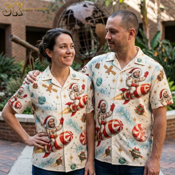 Couple wearing matching Christmas aloha shirts with astronaut Santa candy cane rocket and gingerbread men print in cream, red, and green