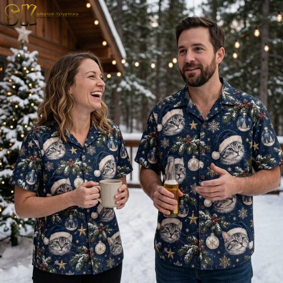 Couple wearing matching Christmas Hawaiian shirts with cats in Santa hats, dark blue holiday print with snowflakes and gold star motifs