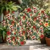 Christmas Hawaiian shirt mens style shown front and back on hanger, beige background with hibiscus, pineapple, red ornaments, and Santa hat face print