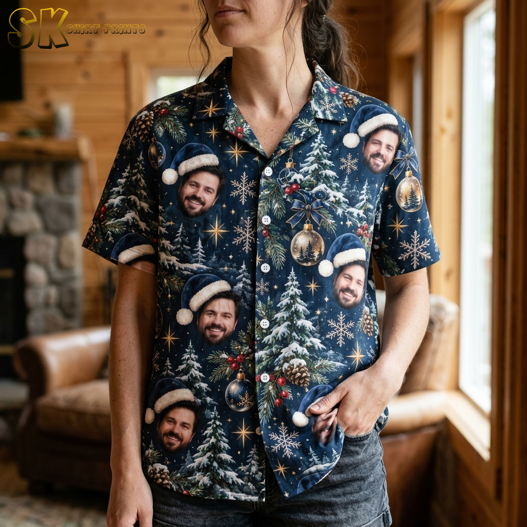 Close-up of a woman wearing a Christmas Hawaiian shirt womens style, showing detailed Santa hat faces, snowflakes, holly berries, and gold ornaments on dark blue fabric