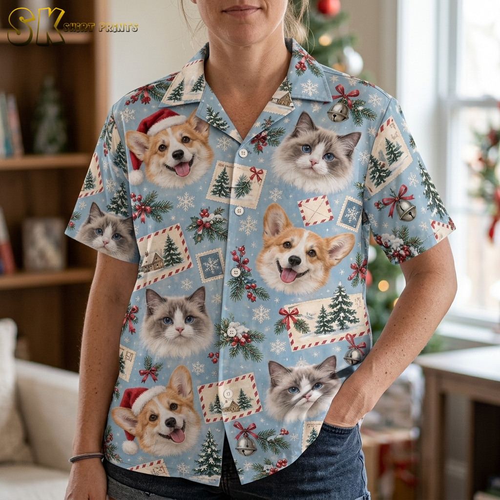 Closeup of a woman wearing a Christmas pet shirt showing detailed corgi dogs in Santa hats, cats, holly, bells, and snowflakes on a light blue background