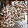 Christmas Santa Hawaiian shirt on hanger showing front and back, cream background with red and green Santa portrait stamp motifs, steam trains, snowy villages, and holly bells