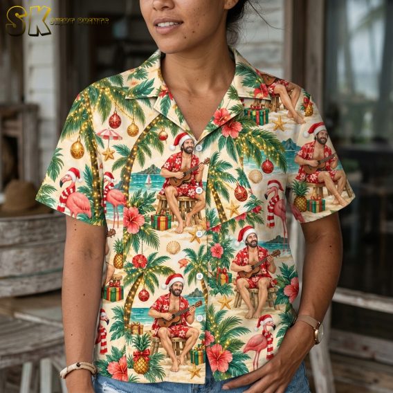 Close-up of a woman wearing a Christmas tiki shirt showing detail of Santa ukulele figure, hibiscus flowers, flamingos, candy canes, and Christmas ornaments in red and green