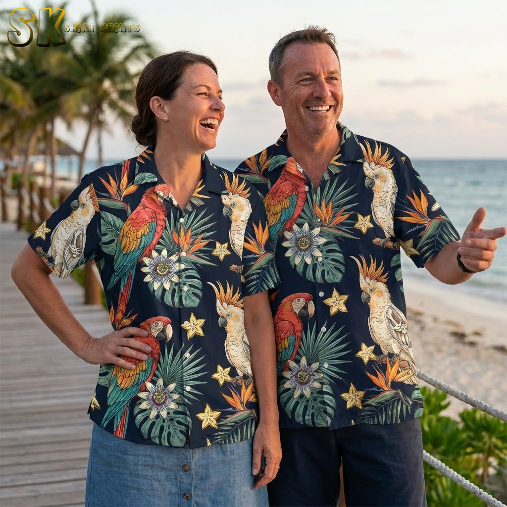Couple wearing halloween hawaiian shirts in multiple colorways showing full collection range with tropical parrot and foliage print