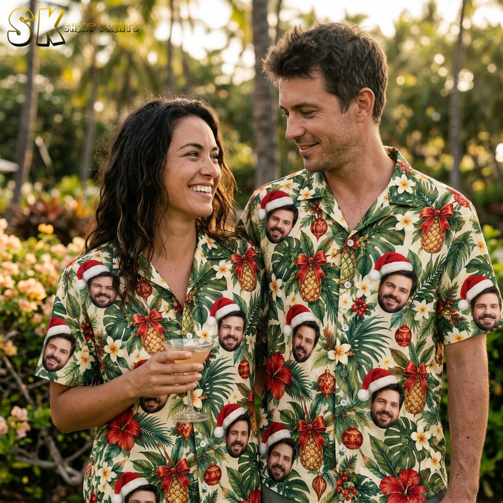 Couple wearing matching Hawaiian Christmas shirts with tropical Santa hat face print, hibiscus, pineapples, and red ornaments on beige