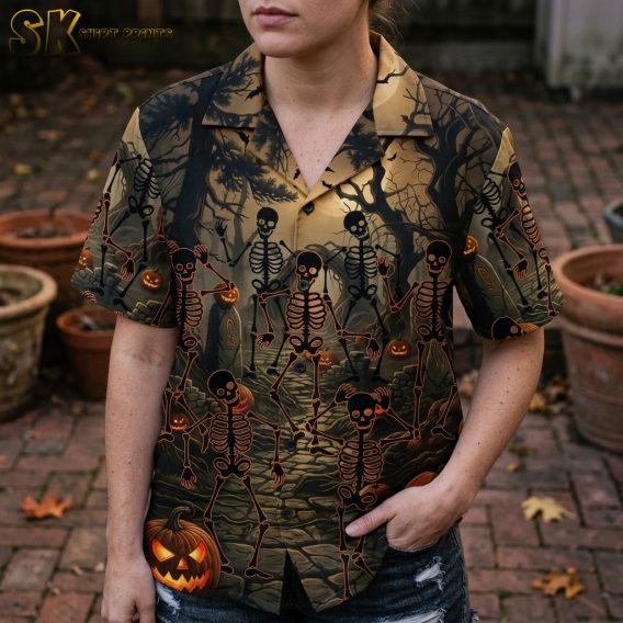 Female closeup of a horror themed Hawaiian shirt showing detailed skeleton, jack-o'-lantern, bat, and twisted tree print in black and orange