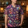Man wearing a mens christmas hawaiian shirt with space Santa, reindeer, planets, and disco ball print in purple and blue