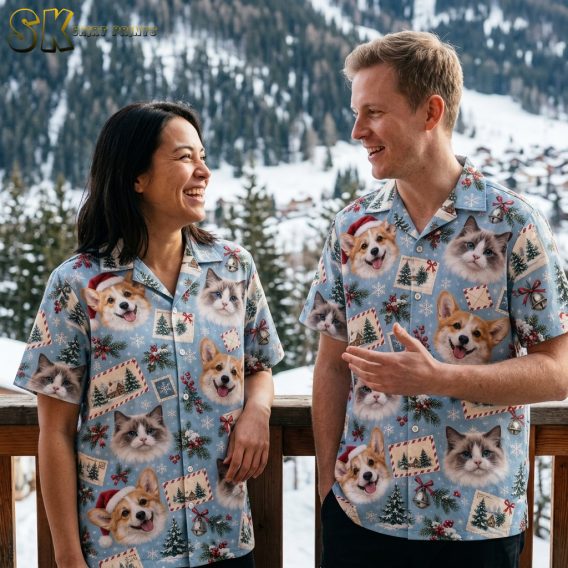 Couple wearing matching tropical Christmas shirts with corgi dogs in Santa hats and cat print on light blue background