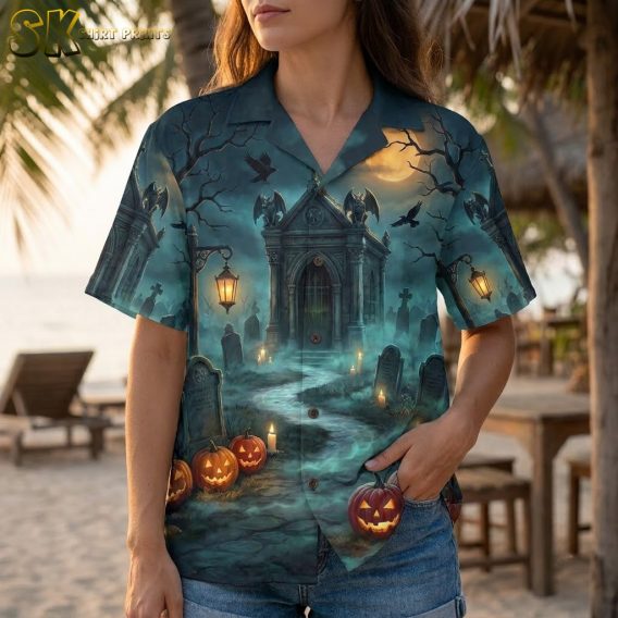Close-up of a woman wearing a spooky Hawaiian shirt with detailed haunted graveyard print showing jack-o-lanterns, bats, and glowing lanterns on dark blue fabric