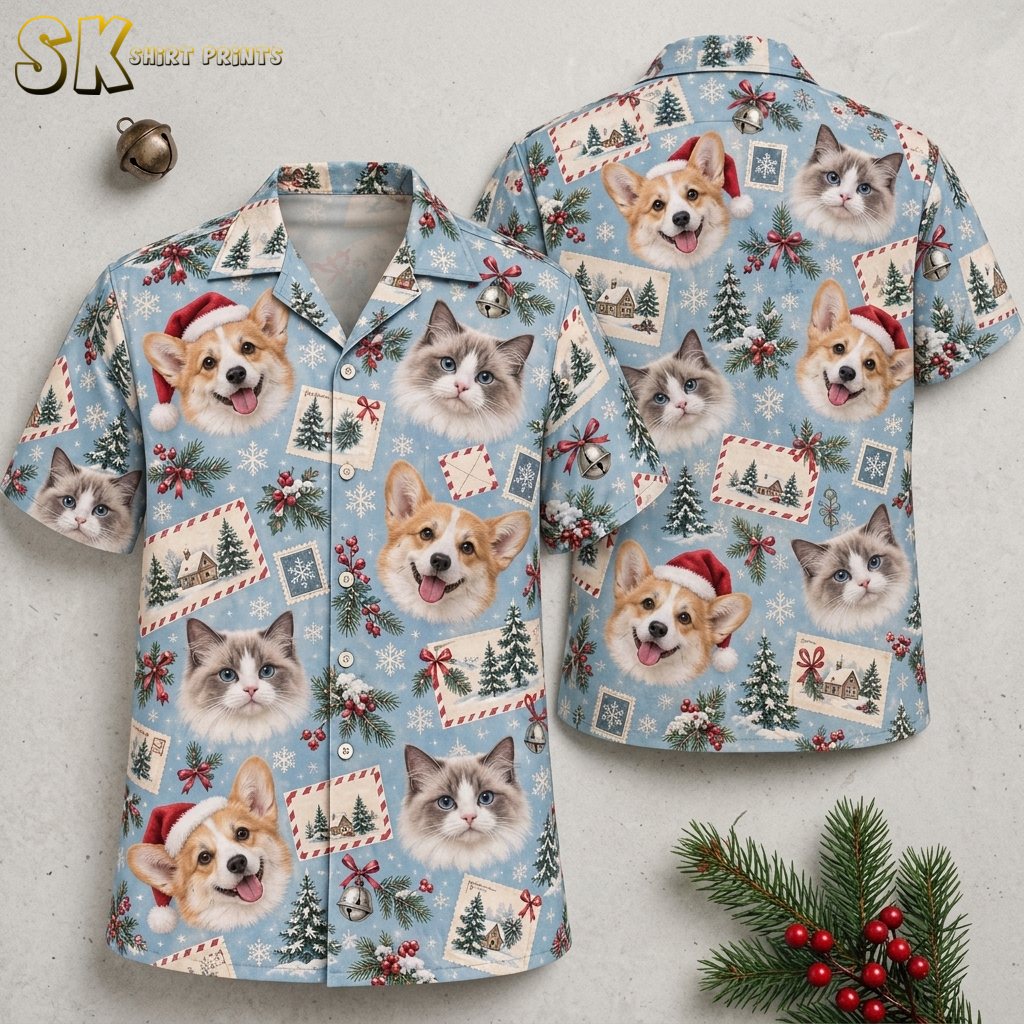 Flat lay of a tropical Santa shirt showing front and back with corgi dogs in Santa hats, cats, Christmas trees, holly, and snowflakes on a light blue background