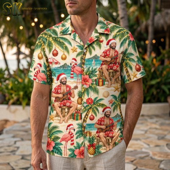 Man wearing a tropical Santa shirt with Santa ukulele print, palm trees, flamingos, and Christmas ornaments in red and green on a short-sleeve button-up