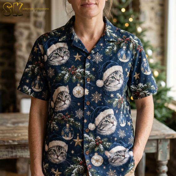 Close-up of a woman wearing a dark blue womens Hawaiian Christmas shirt showing detailed cats in Santa hats, snowflakes, pine branches, and Christmas baubles