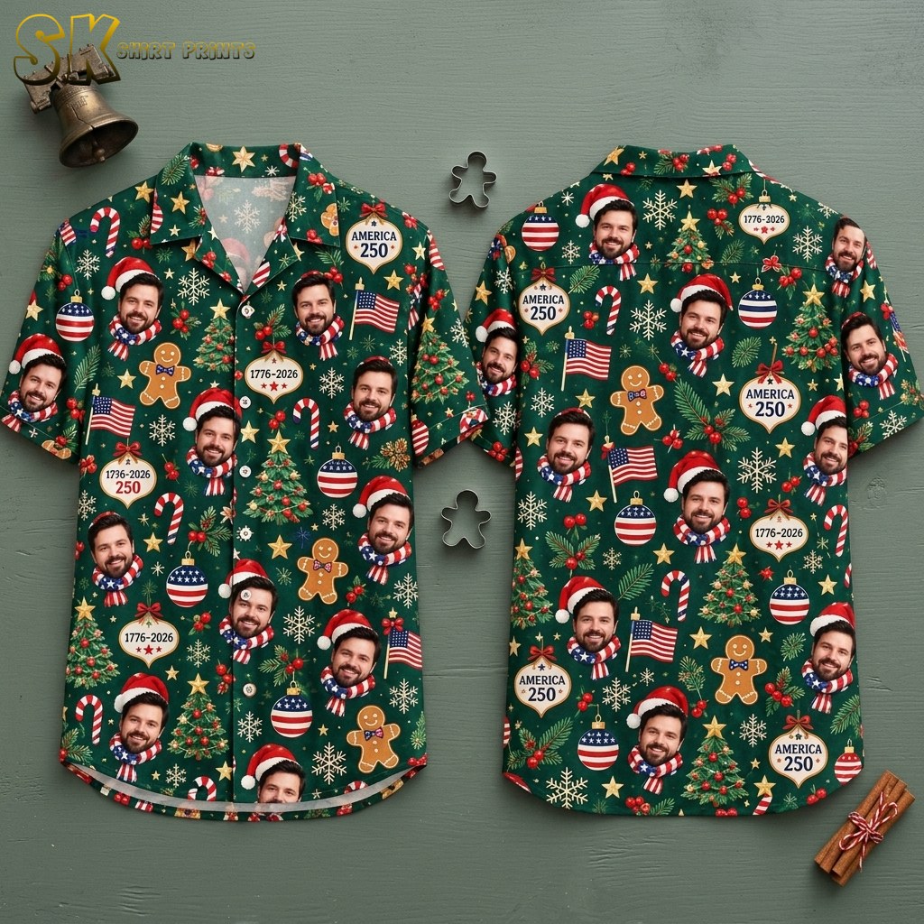 Front and back hanger view of a dark green short-sleeve button-up shirt covered in a dense all-over pattern of a smiling bearded man in a Santa hat and American flag scarf, gingerbread men, decorated Christmas trees, and ornaments printed with AMERICA 250 and 1776-2026, accented by candy canes, American flags, snowflakes, gold stars, and red-white-and-blue baubles.