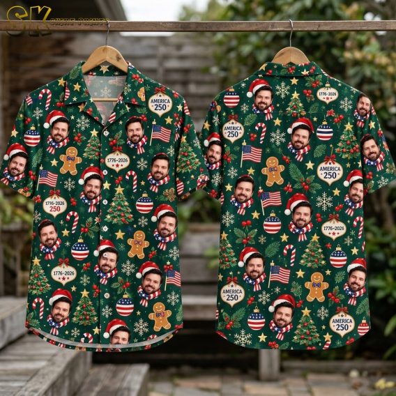 Flat-lay view of the dark green short-sleeve button-up shirt laid out to show both the front and back panels, with the full all-over pattern of smiling Santa-hat faces, gingerbread men, Christmas trees, candy canes, American flags, and AMERICA 250 ornaments spread evenly across the fabric.