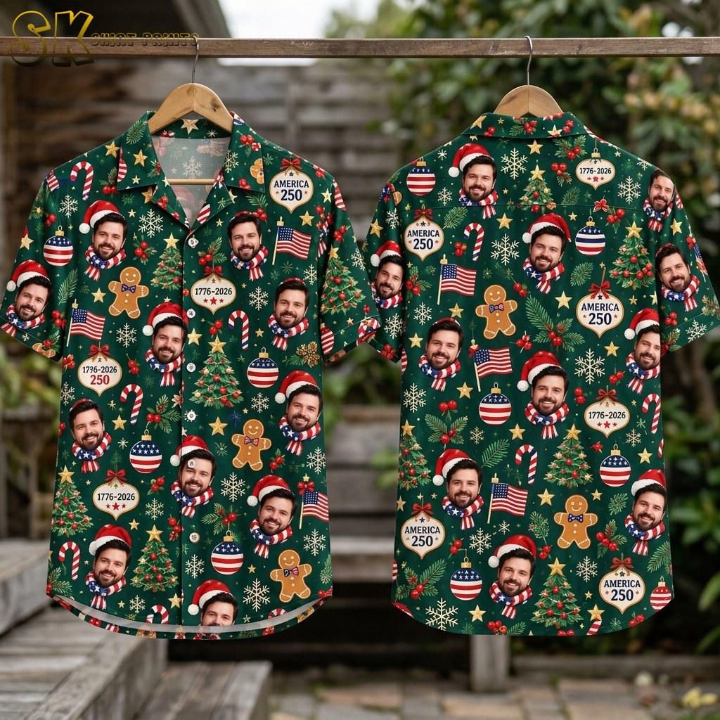Flat-lay view of the dark green short-sleeve button-up shirt laid out to show both the front and back panels, with the full all-over pattern of smiling Santa-hat faces, gingerbread men, Christmas trees, candy canes, American flags, and AMERICA 250 ornaments spread evenly across the fabric.
