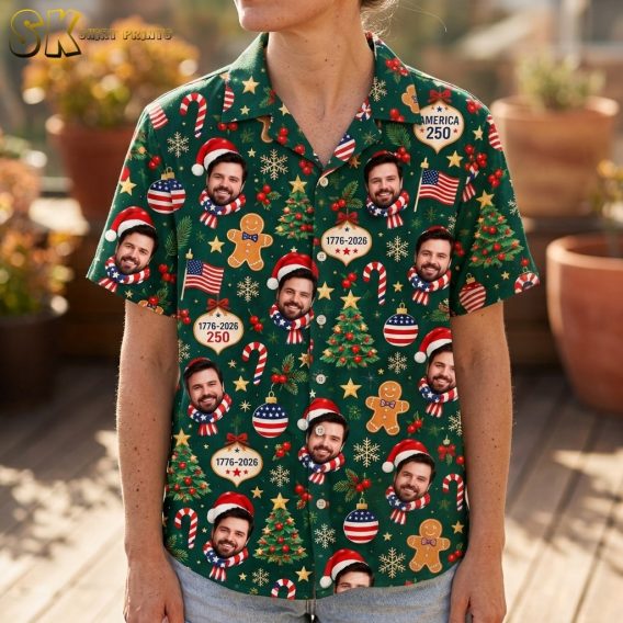 A close-up view of the shirt's fabric showing the repeating photorealistic face of a bearded man wearing a Santa hat and American flag scarf, surrounded by gingerbread men, pine branches with red berries, candy canes, and gold stars on a dark green background.