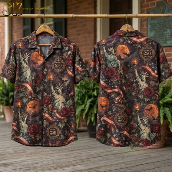 Flat lay of halloween themed hawaiian shirts showing front and back panels with Statue of Liberty, orange moons, bats, roses, and America 250 text on a dark blackish-brown base.