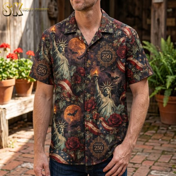 Man wearing a mens halloween hawaiian shirt featuring Statue of Liberty, orange moons, bats, and dark red roses on a blackish-brown background.