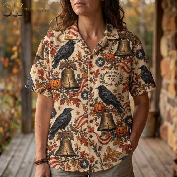 Close-up of a woman wearing a halloween hawaiian shirt, showing detailed artwork of ravens, Liberty Bells, pumpkins, stars, and autumn leaves.