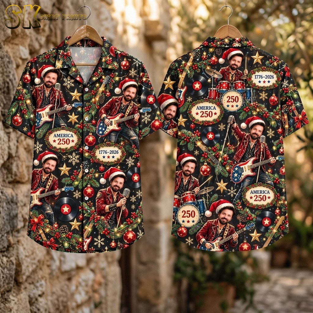 Flat lay showing the front and back of the black short-sleeve button-up shirt laid out flat, with the full pattern of the Santa-hat musician, pine branches, red bows, snowflakes, and America 250 text visible across both panels.