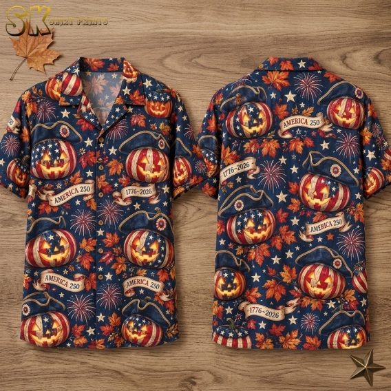 Front and back views of a navy blue short-sleeve button-up shirt hanging on a hanger, covered in an all-over pattern of flag-decorated jack-o'-lanterns wearing tricorn hats, orange maple leaves, fireworks bursts, and ribbon banners reading AMERICA 250 and 1776-2026.