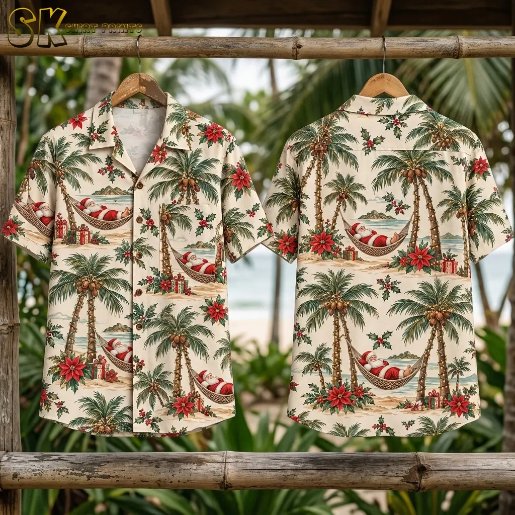 Front and back of a cream Hawaiian shirt with Santa Claus hang from a bamboo rail with palm foliage and the ocean behind them.