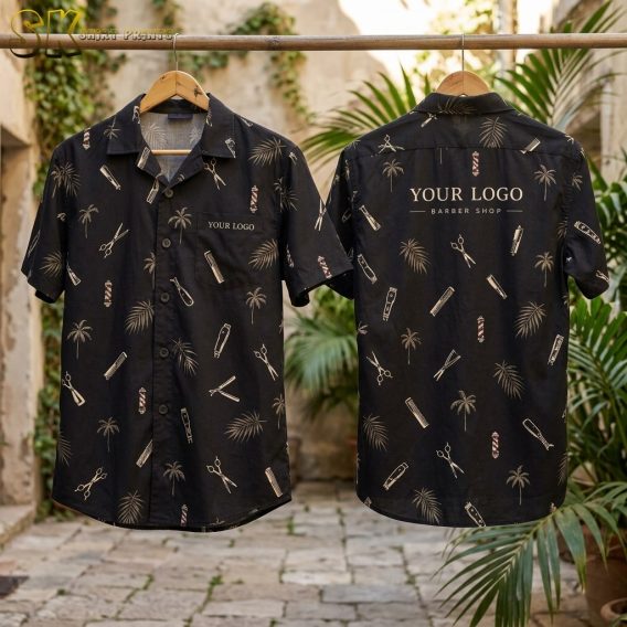 Two black short-sleeve shirts hang on wooden hangers outdoors, showing front and back views with a barber-tools-and-palm-tree pattern and placeholder logo text on the chest pocket and upper back.