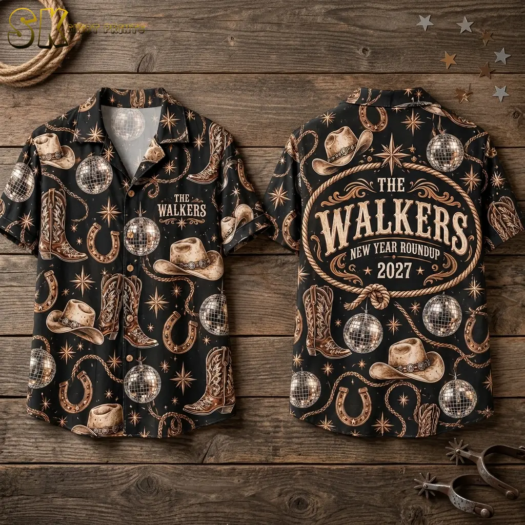 Two black Western New Year shirts lie on wood planks, showing the small chest name and large rope-bordered back design.