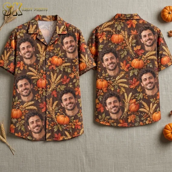 Front and back of a brown short-sleeve shirt laid flat, with smiling male faces, pumpkins, and wheat in an all-over print.