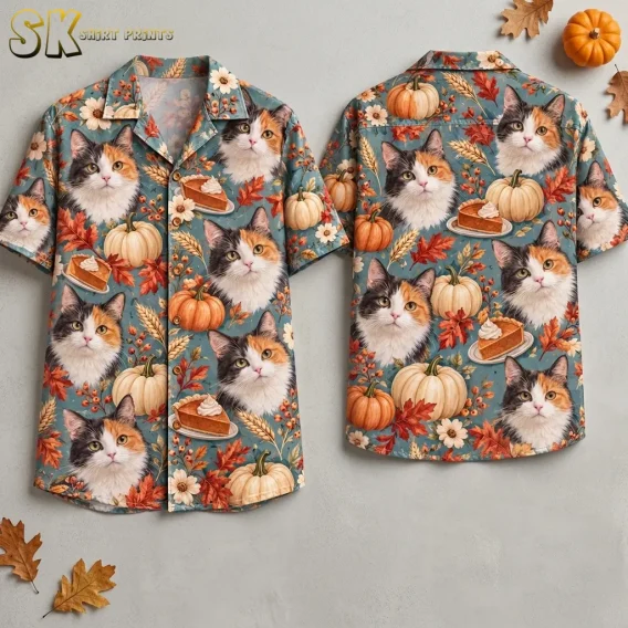 Front and back of a blue Thanksgiving button up shirt with large calico cat faces, pumpkins, and pumpkin pie, displayed against a gray background.