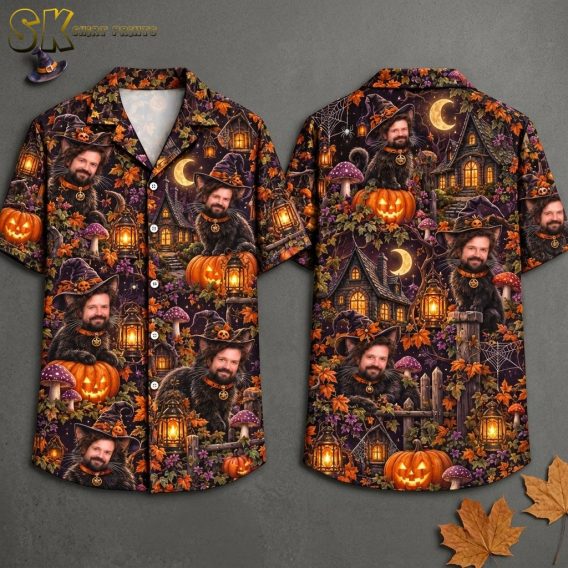 Front and back views of a short-sleeve button-up shirt on a hanger, showing an all-over print featuring a black cat with a man's face wearing a purple witch's hat, surrounded by glowing jack-o'-lanterns, crescent moons, and haunted houses on a dark purple background.