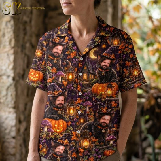 A close-up view on a female model highlighting the shirt's detailed print, including the black cat with a man's face wearing a purple witch's hat, spider webs, mushrooms, and glowing lanterns against a dark purple background.