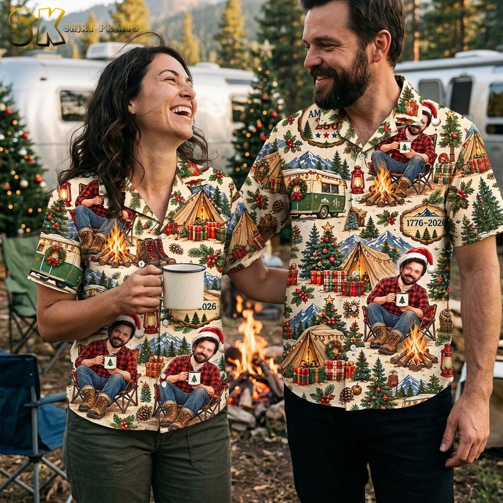 A couple wearing the short-sleeve button-up shirt printed with campfire scenes, vintage green camper vans, pine trees, and a man in a Santa hat on a beige background.