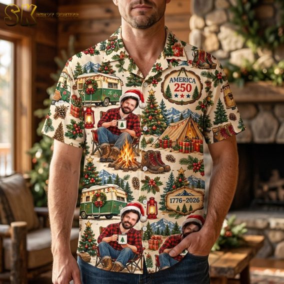 A man wearing the short-sleeve button-up shirt featuring a beige background with campfire scenes, green camper vans, and Christmas tree motifs.