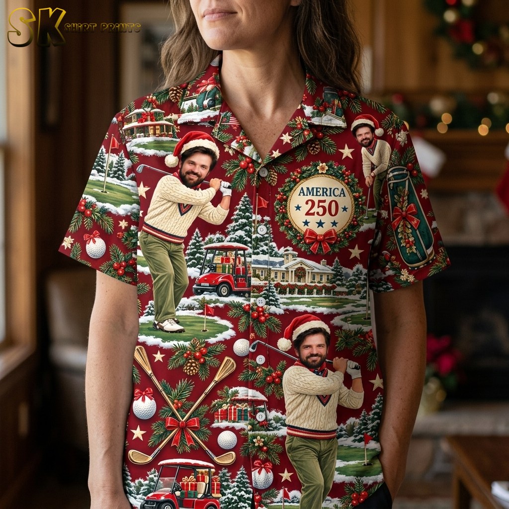 A close-up view of the shirt's printed fabric showing detailed illustrations of a man in a cream cable-knit sweater and Santa hat, holly berries, pine branches, white ornaments, and the text America 250 inside a wreath with crossed golf clubs.