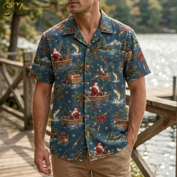 A man wearing christmas hawaiian shirts for men stands on a wooden dock near a lake, with the Santa-fishing print and red bow accents visible across the chest and front pocket.