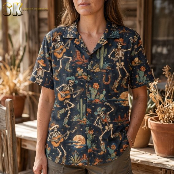A close-up view of the shirt worn by a woman, highlighting the vintage hand-drawn illustration style of the skeleton cowboys in dynamic dancing poses with rusty orange, teal, and beige accents on the navy base.