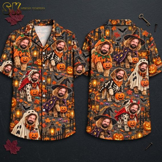 Short-sleeve button-up shirt on a hanger showing the front and back, covered in a dense all-over pattern of bearded dogs dressed in Halloween costumes and carrying jack-o'-lantern candy buckets against a dark nighttime background with bats, lanterns, and fall leaves.