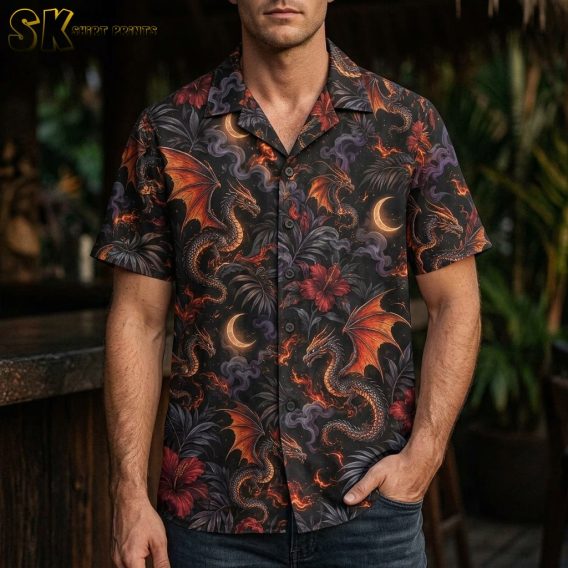 A man wearing a black short-sleeve button-up shirt featuring large fire-breathing dragons with orange wings, set against red hibiscus flowers and dark palm foliage.