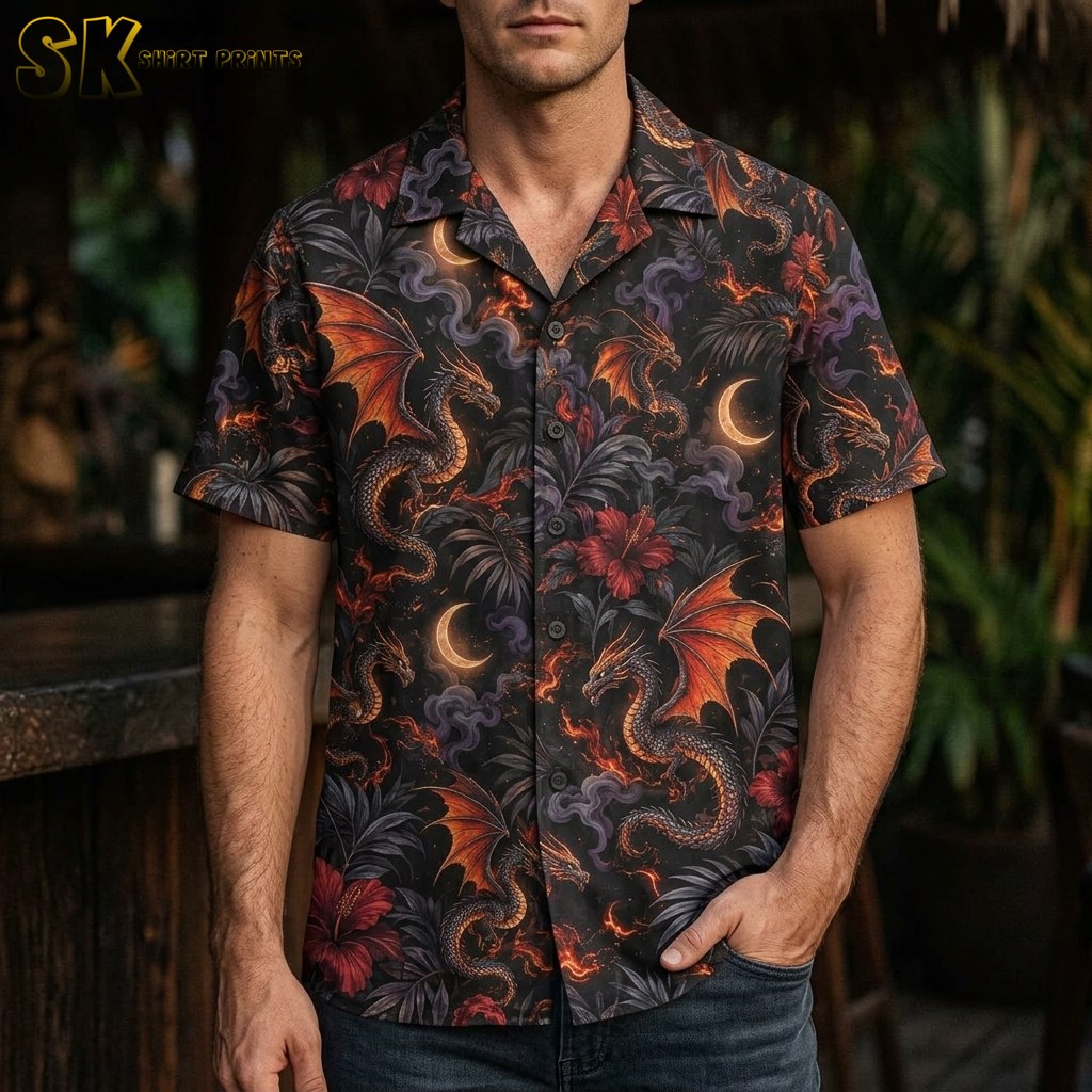A man wearing a black short-sleeve button-up shirt featuring large fire-breathing dragons with orange wings, set against red hibiscus flowers and dark palm foliage.