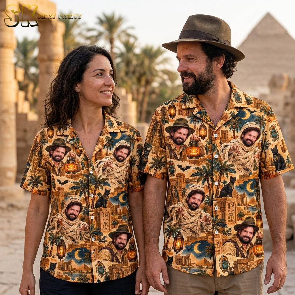 A couple shown together, with one person wearing the sandy beige Egyptian Halloween shirt featuring mummy and explorer portraits, palm trees, and glowing lanterns.